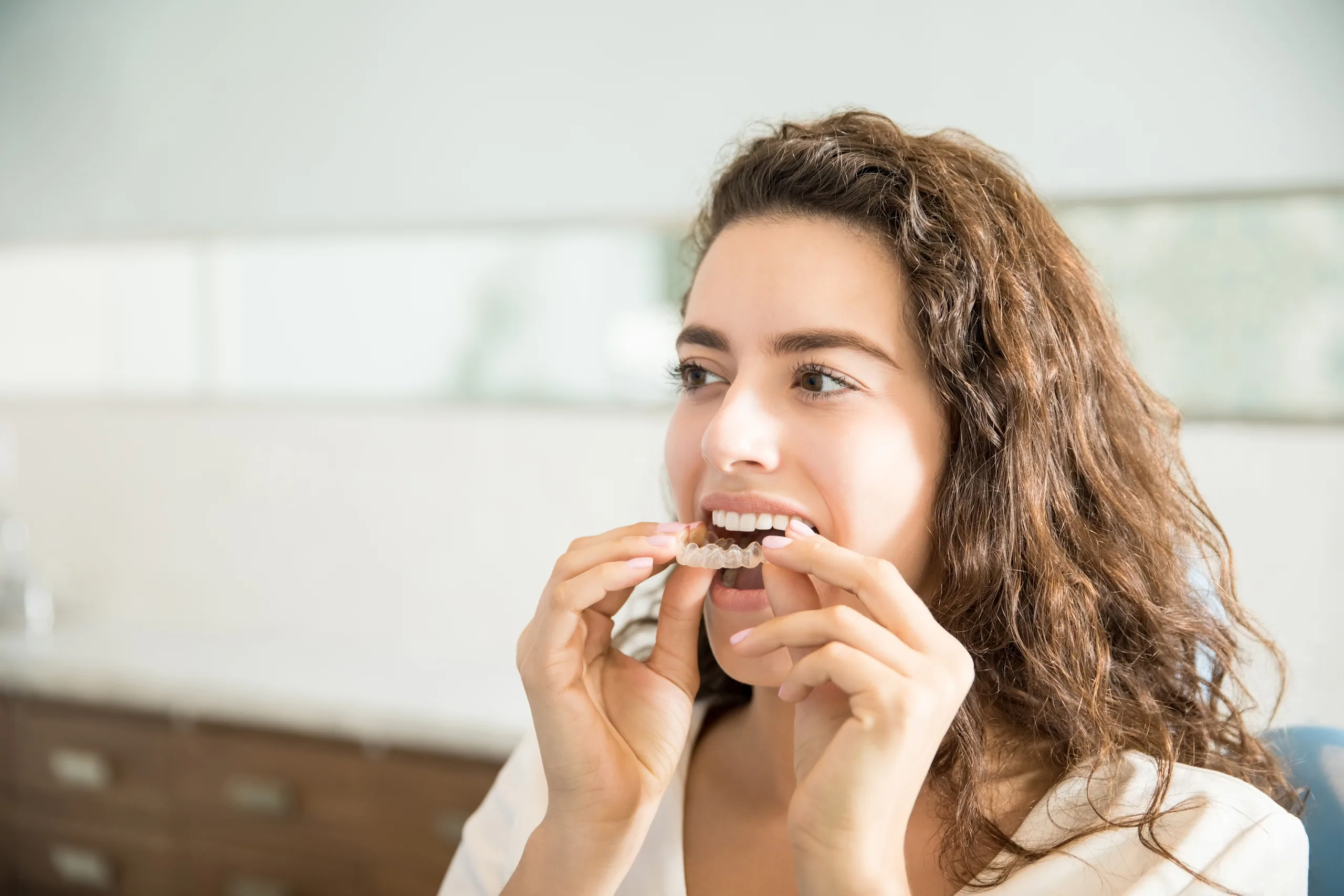 Woman placing clear dental aligners