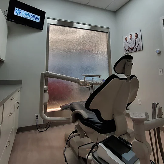 Maine Dentistry treatment room with a dental chair and Invisalign display