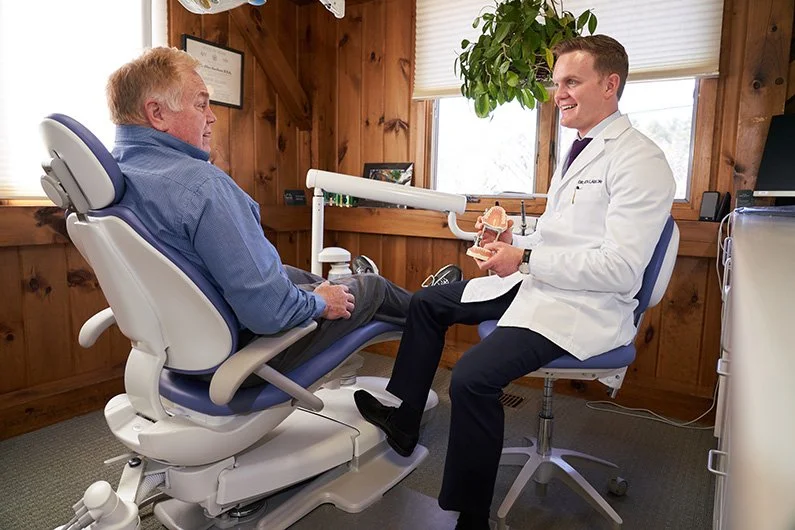 Dr. Lawlor discussing a dental model with a patient in a treatment room